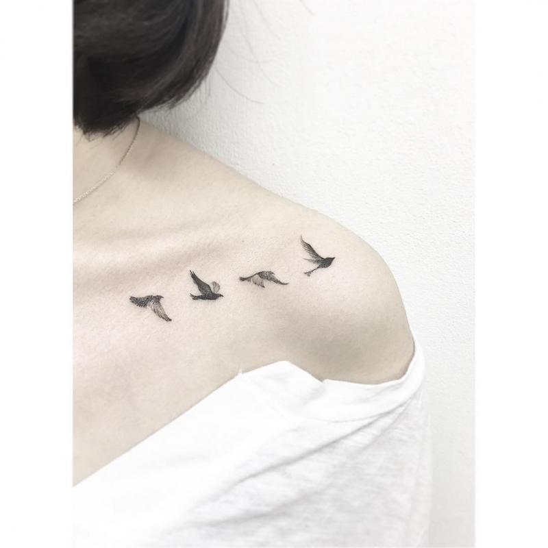 Tatuagem feminina e minimalista de passarinho.